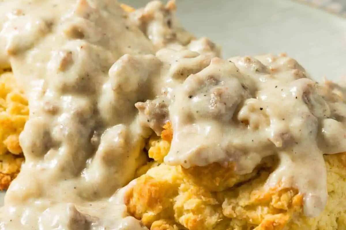A close-up of biscuits topped with white sausage gravy on a plate—perfect for lazy morning recipes or a cozy weekend brunch.