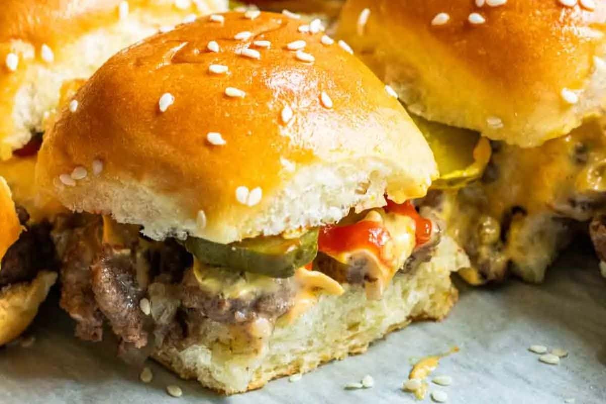 Irresistible close-up of a copycat Big Mac slider with a sesame-seed bun, juicy beef patty, melted cheese, pickles, and ketchup—perfect for Game Day feasting.