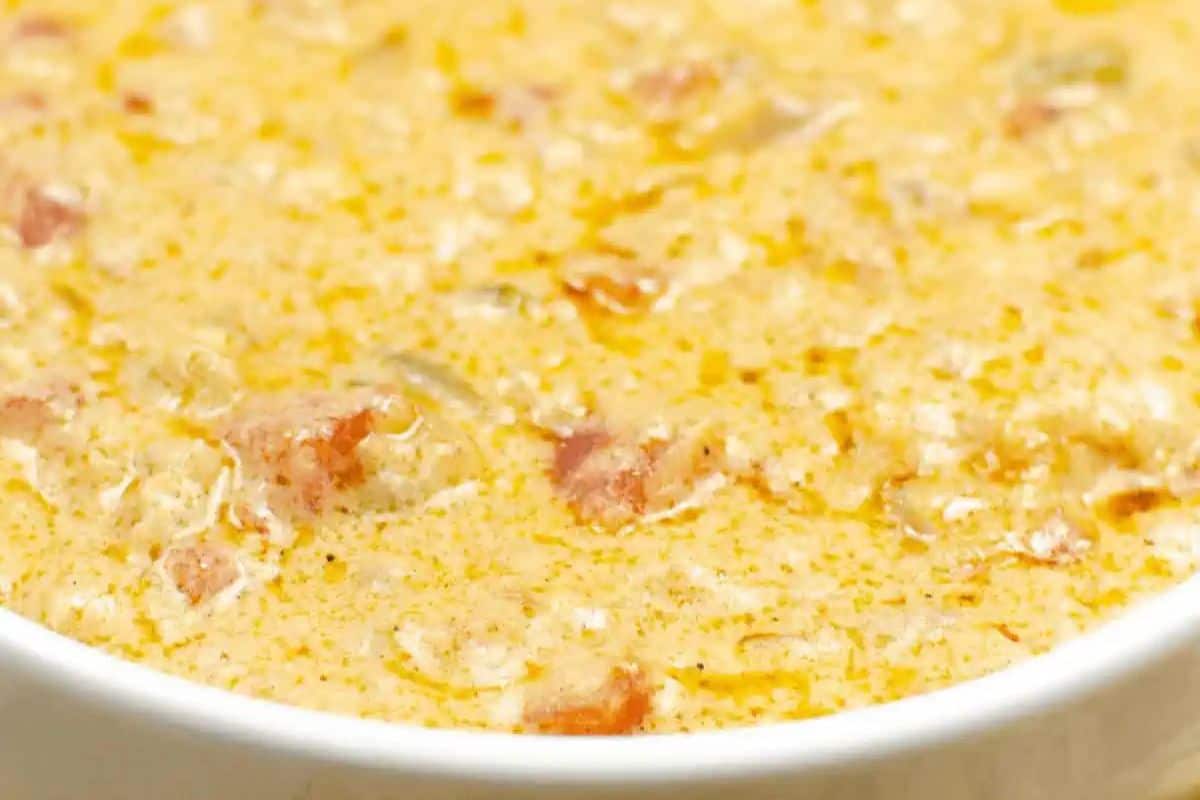 A close-up of a creamy, textured soup with visible chunks of meat and a slight oily sheen on the surface—perfect for scoring big points at your Super Bowl gathering.