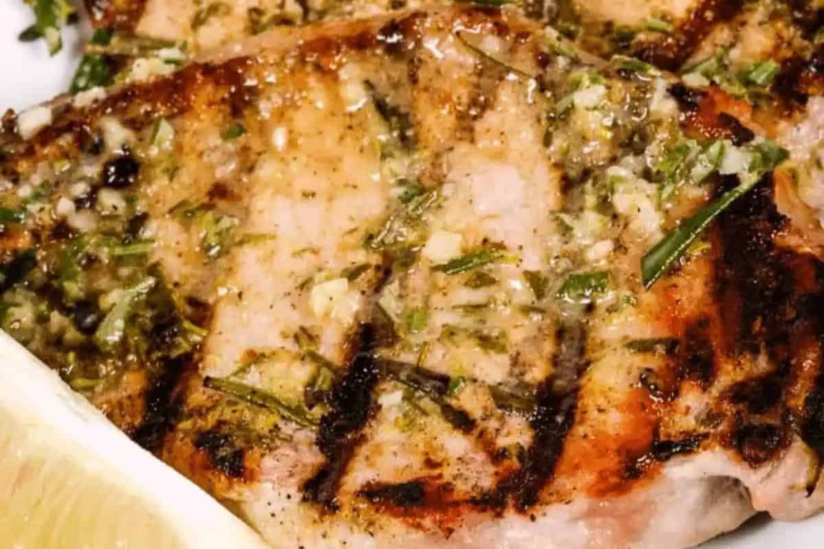 Close-up of some grilled pork chops with a rosemary and garlic rub.