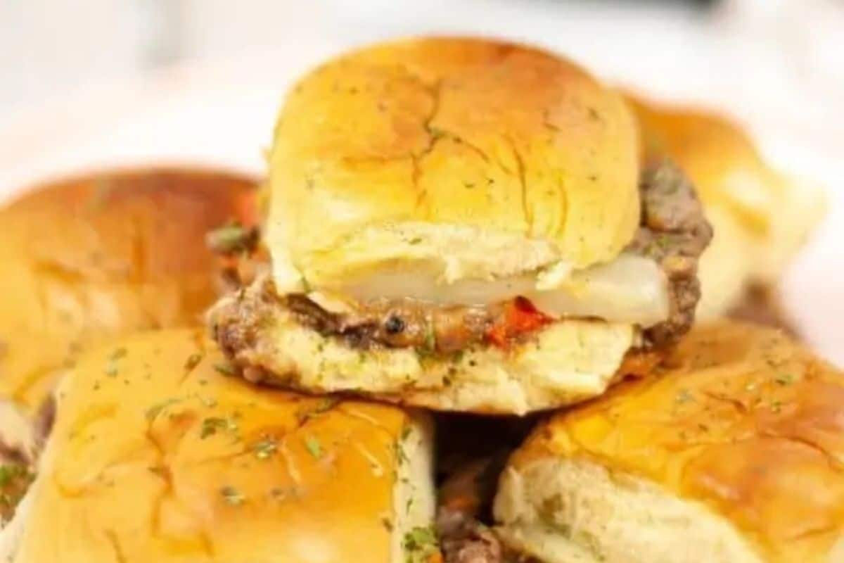Close-up of an irresistible stack of philly cheesesteak sliders with, cheese, and herbs nestled in soft buns, perfect for game day indulgence.