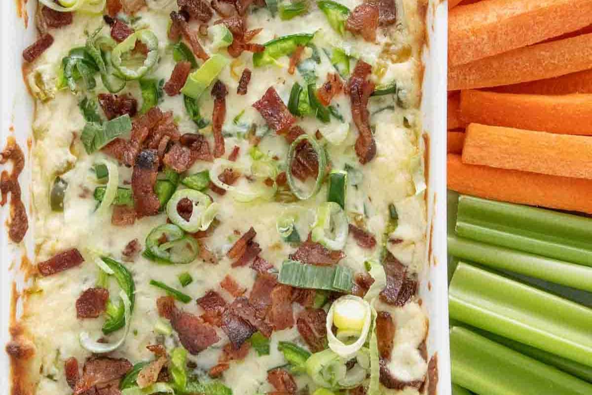 Score big points with this dip, featuring bacon, green onions, and melted cheese beside sliced carrots and celery sticks—perfect for your Super Bowl dips spread.