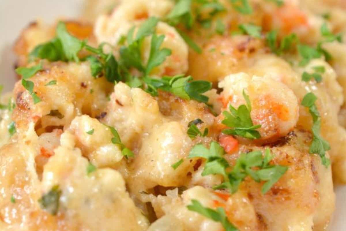 Close-up of a cheesy baked seafood casserole topped with chopped parsley—perfect for cozy nights or as a standout dish for special dinners.