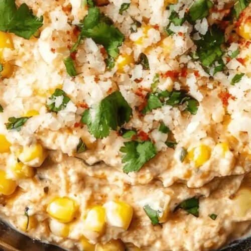 Close-up of an irresistible corn dip topped with cilantro, crumbled cheese, and spices in a bowl—a perfect choice for Super Bowl dips that'll score big points at any gathering.