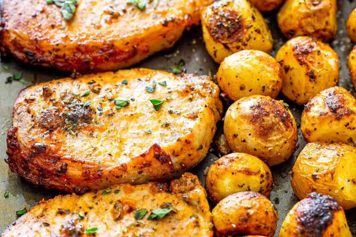 Close-up of some ranch coated pork chops, baked with some ranch potatoes.