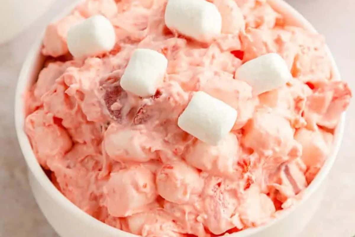 A bowl of pink ambrosia salad topped with small marshmallows is the perfect Valentine treat idea for your little sweethearts.