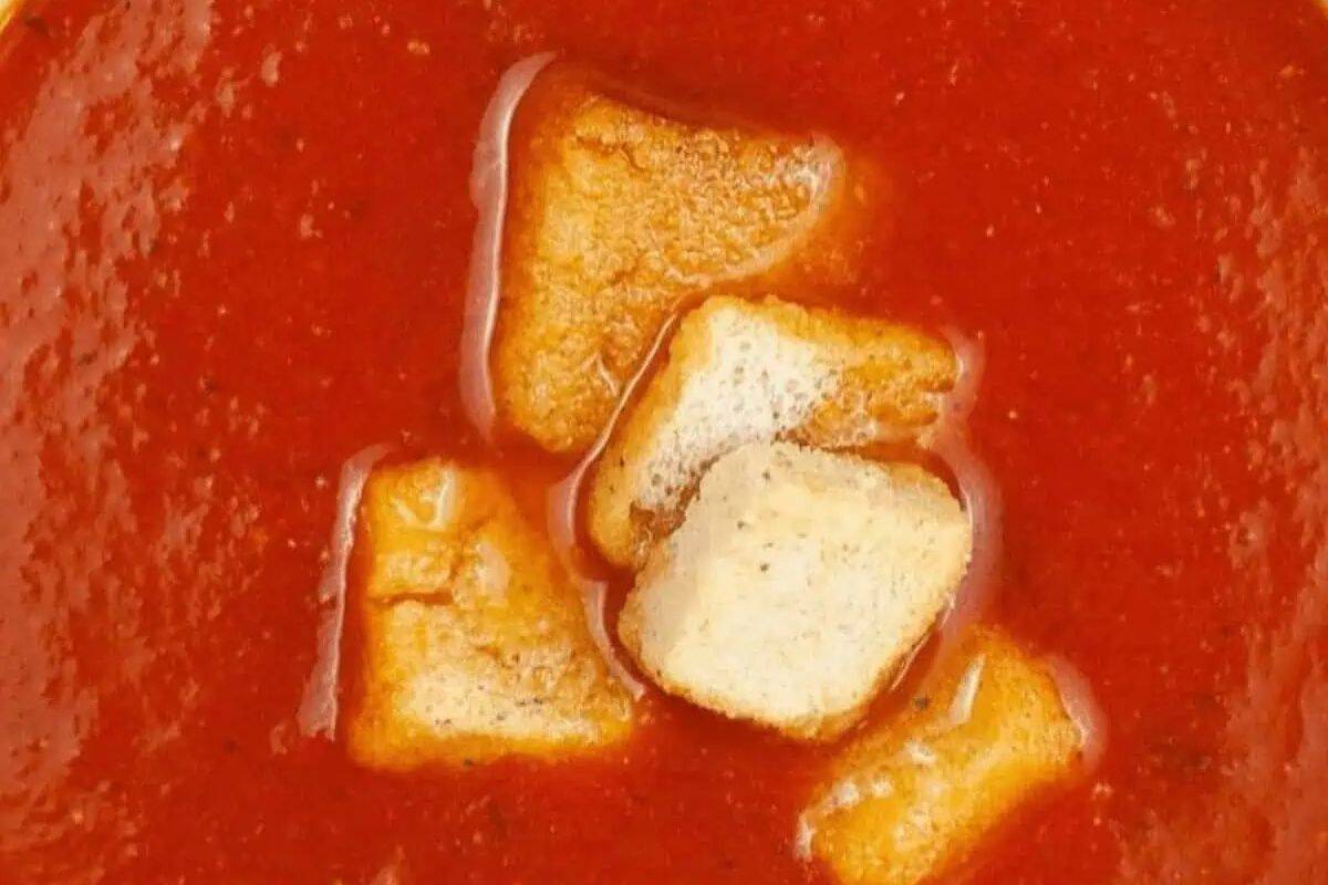 Close-up of tomato soup with several croutons floating on the surface—a classic example of cozy vegetable soups perfect for chilly days.