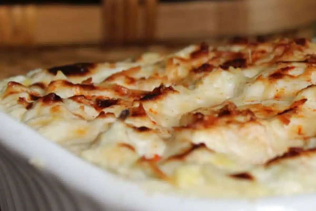 Close-up of a baked casserole dish with a golden, bubbly, and slightly browned cheese topping—perfect for cozy nights or special dinners.