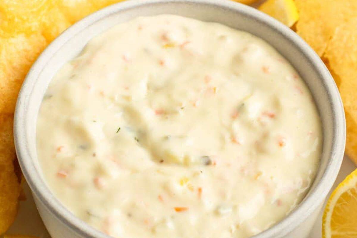 A bowl of creamy tartar sauce, just like Red Lobster’s, surrounded by fried food and lemon wedges—perfect to make at home.