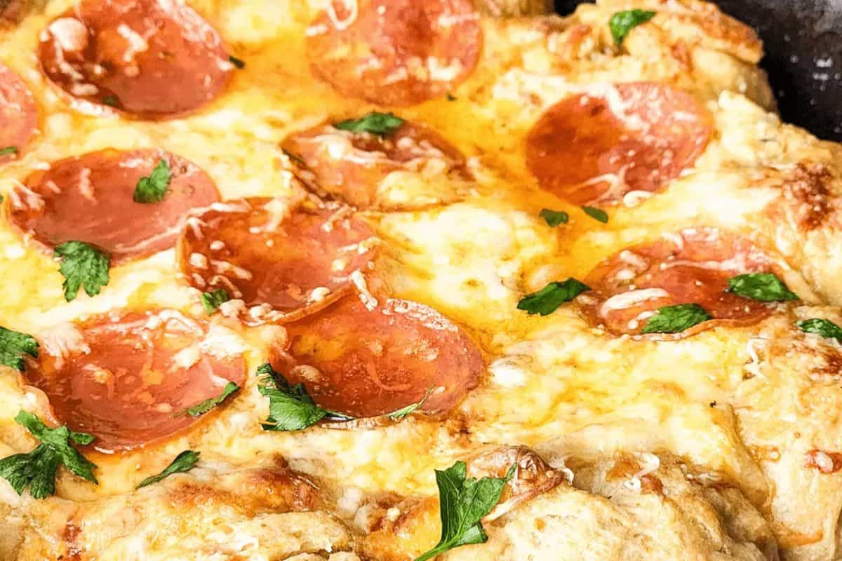 Close-up of a baked pepperoni pizza topped with melted cheese, sliced pepperoni, and fresh parsley on a golden crust—perfect to serve alongside your favorite Slow Cooker Dips for the ultimate party spread.