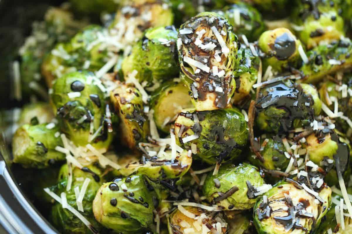 Roasted Brussels sprouts topped with shredded parmesan cheese and drizzled with balsamic glaze make an easy dinner side dish that pairs perfectly with your favorite dinner recipes.