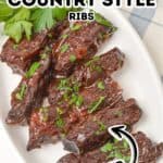 Oval plate with Baked Country Style Ribs garnished with chopped parsley, labeled as "tender," on a light cloth background.