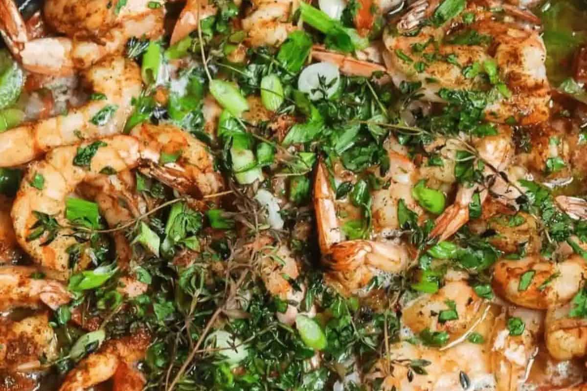 Close-up of cooked Caribbean jerked shrimp seasoned with herbs, delivering restaurant-quality flavor. Garnished with chopped green onions and various herbs, this dish embodies elegance found in top-tier shrimp dishes.