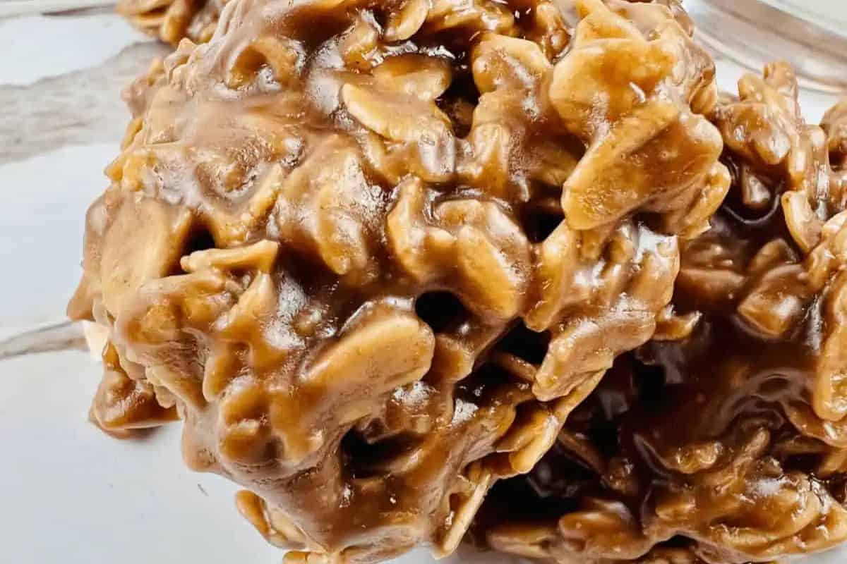 Close-up of peanut butter chocolate oatmeal no-bake cookies on a light surface. These easy treats boast a lumpy texture with oats peeking through, making them a delightful contender in the dessert game.