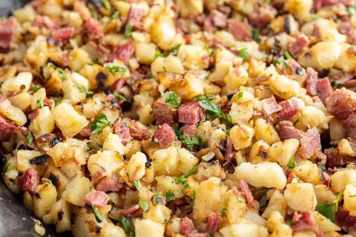 A close-up of a classic breakfast dish featuring chopped corned beef and diced potatoes, garnished with parsley, perfect for savoring on St. Patrick's Day.