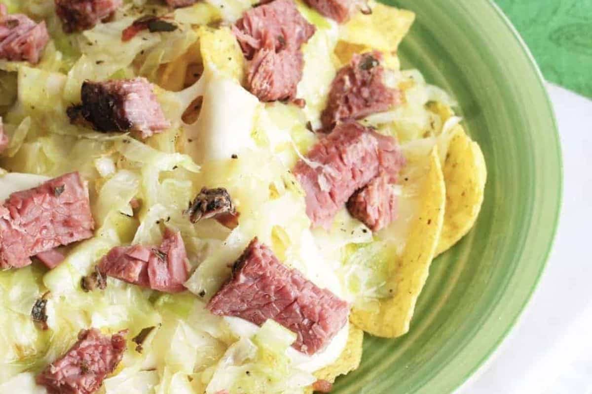 Discover a vibrant twist on nachos with this delicious combination: a green plate brimming with corned beef pieces, shredded cabbage, and melted cheese. Whether you're exploring cabbage recipes or blending traditional & modern recipes, this dish is sure to satisfy.