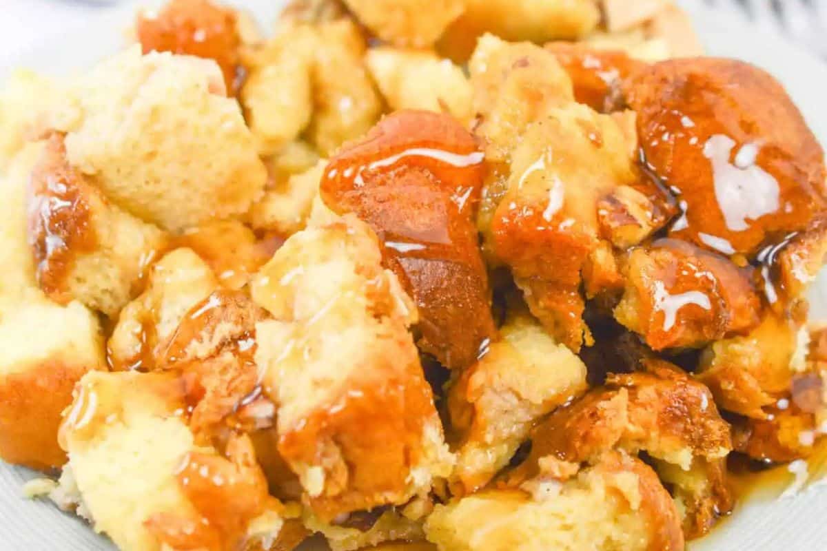 Close-up of french toast with apples, perfect for a festive St. Patrick's Day brunch. The cubes of bread are luxuriously coated with a glossy, maple syrup, inviting you to indulge in its rich sweetness.