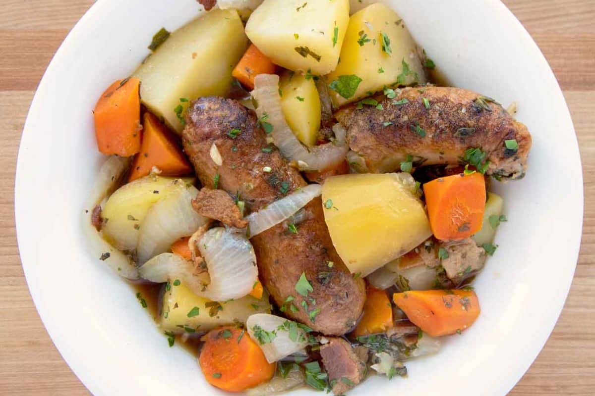 An Irish-inspired dublin coddle with chicken sausage with sausages, potatoes, carrots, and onions, garnished with herbs to warm your soul.