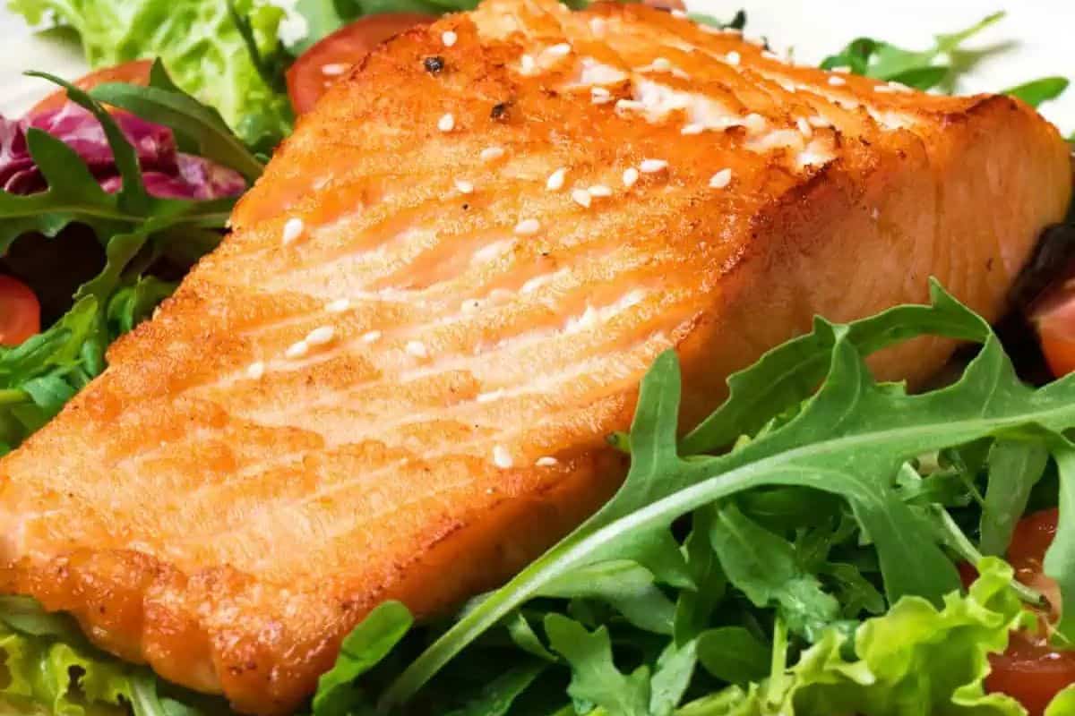 Irresistible grilled salmon fillet on a bed of mixed greens with cherry tomatoes—an enticing dish everyone will love.
