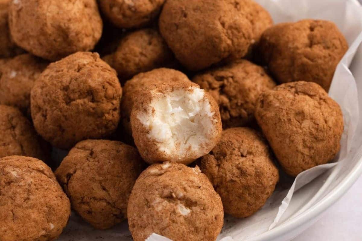 A bowl of irish potato candy, with one partially eaten to reveal a white interior, offers an Irish-inspired comfort food delight that promises to warm your soul.