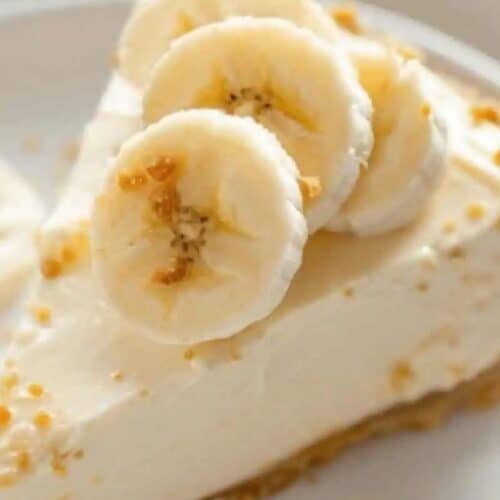 A slice of banana cream pie on a plate, featuring a graham cracker crust and topped with banana slices, perfect for elevating your no-bake dessert game.