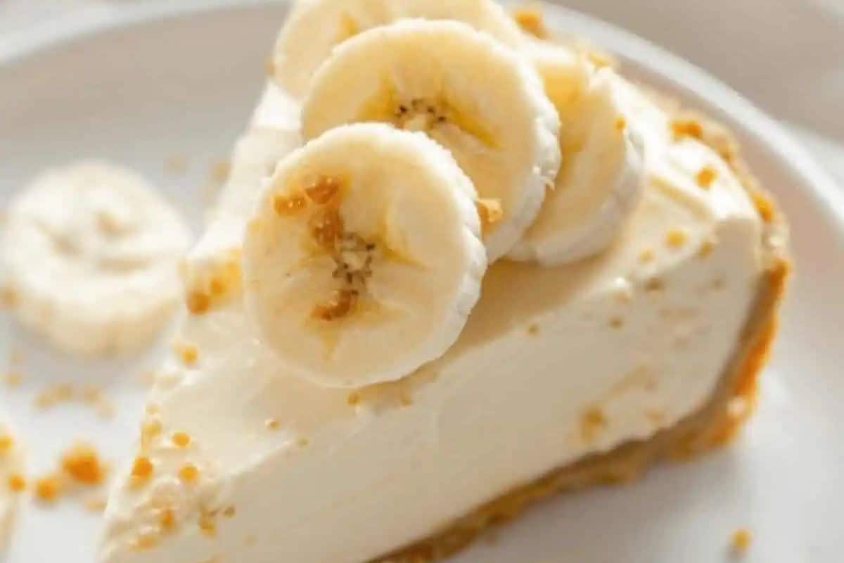 A slice of banana cheesecake on a plate, featuring a graham cracker crust and topped with banana slices, perfect for elevating your no-bake dessert game.