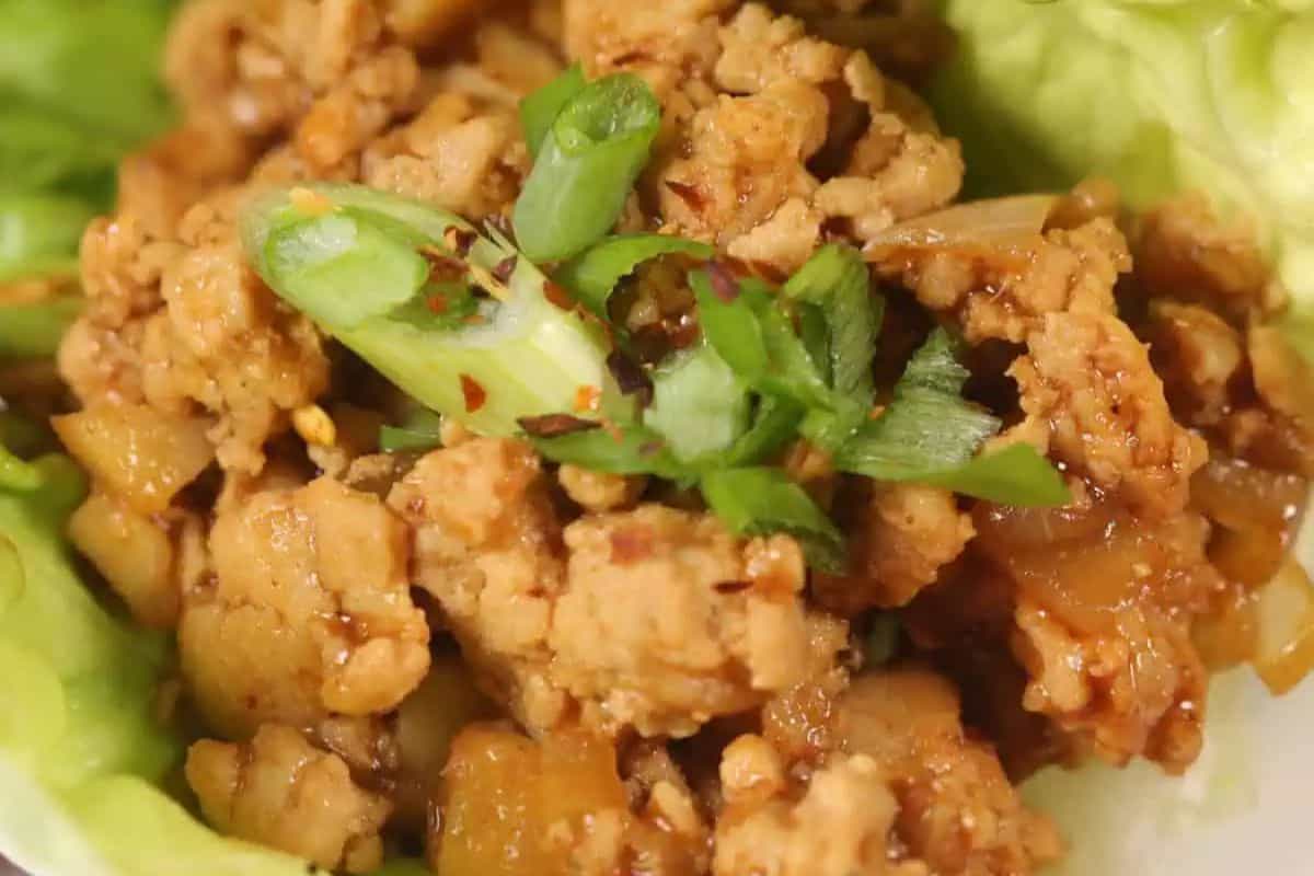 A close-up of seasoned ground chicken with chopped green onions, served on a bed of lettuce leaves—perfect for those seeking Easy Weight Watchers Recipes.