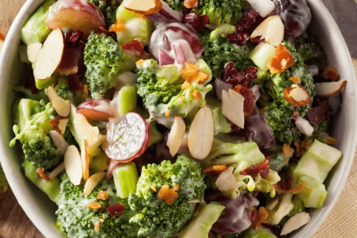 Bowl of broccoli salad with sliced almonds, grapes, bacon bits, and a creamy dressing—perfect for potluck recipes or a crowd-pleasing St. Patrick's Day gathering.