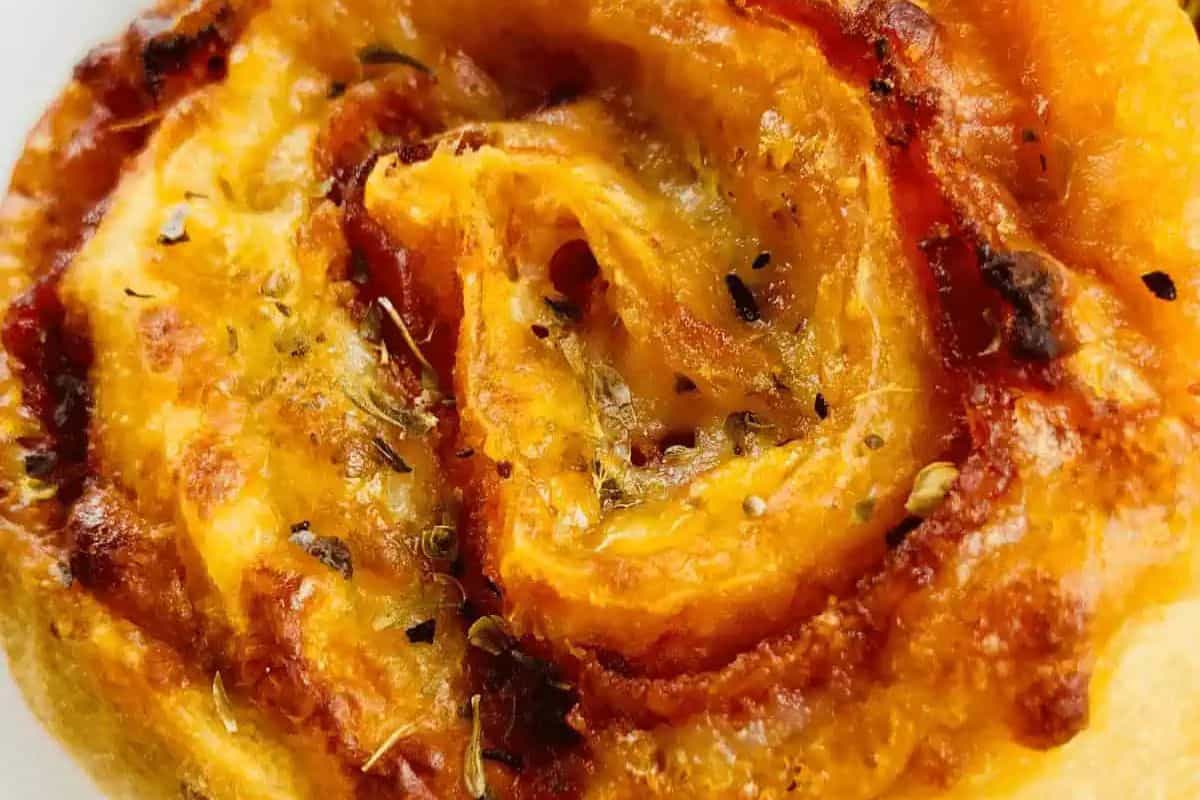 Close-up of a savory pepperoni pizza roll with swirled layers, topped with herbs and baked to a golden brown—an ideal treat for the perfect night in.