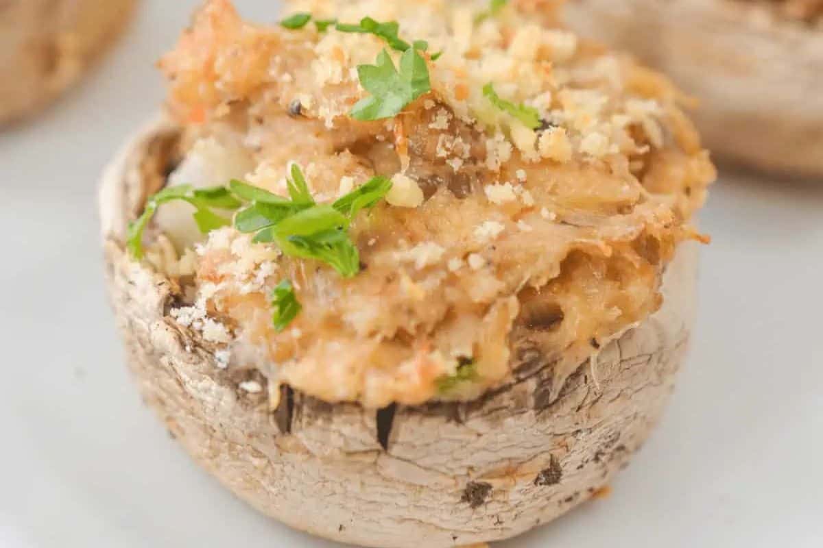 Close-up of a stuffed mushroom with a creamy filling and breadcrumb topping.