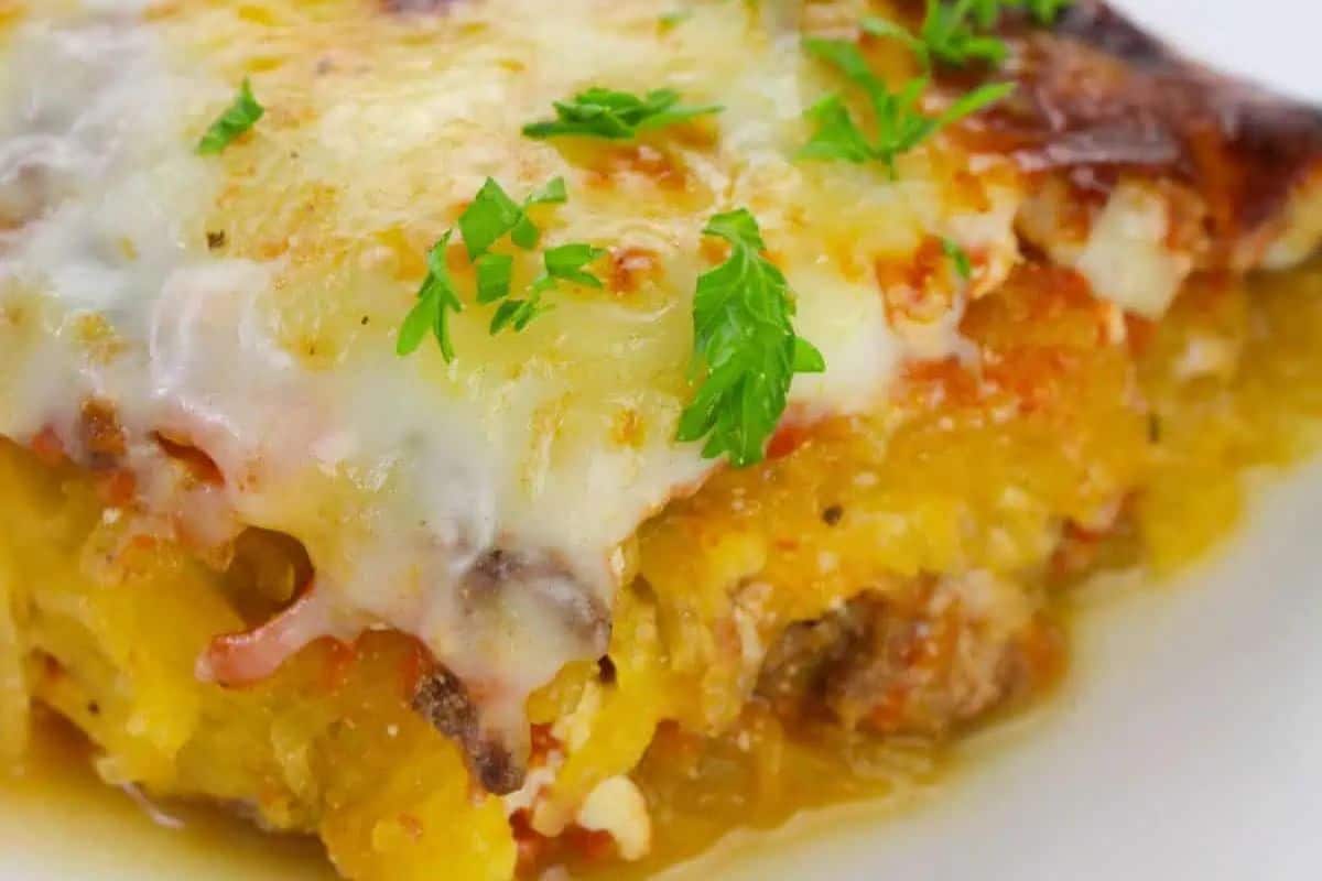 Close-up of a baked cheesy casserole topped with melted cheese and garnished with chopped parsley on a white plate—one of the Easy Weight Watchers Recipes perfect for a satisfying meal.
