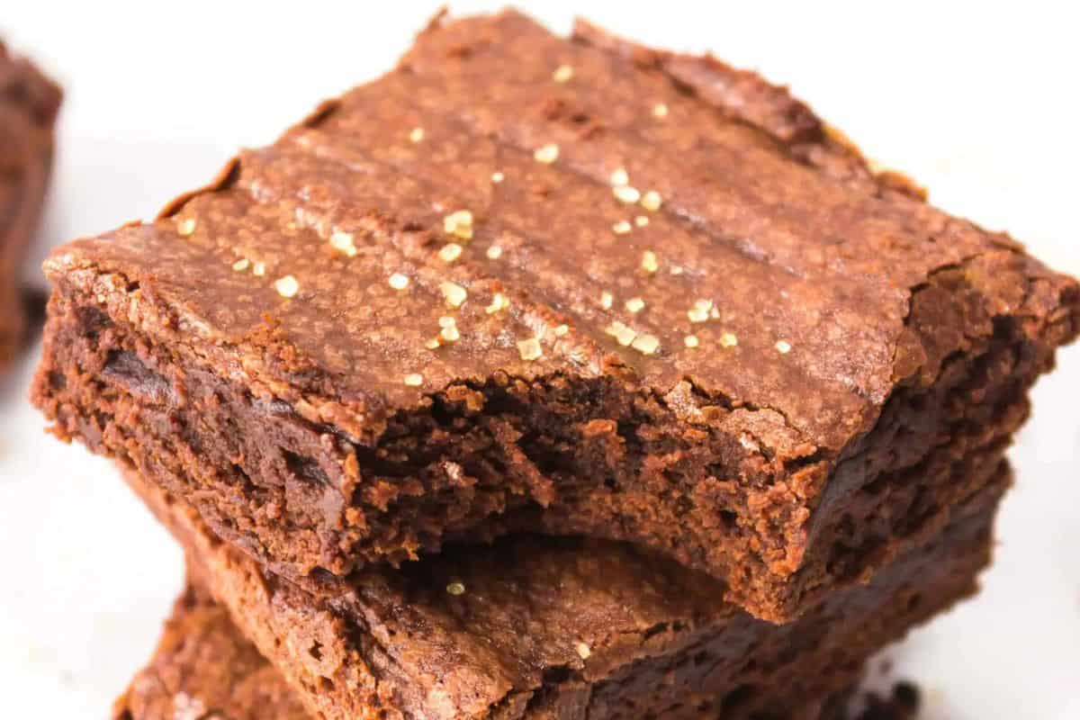 Close-up of two stacked brownies with a slightly flaky top and a textured surface, showcasing the rich indulgence only chocolate bars can offer.