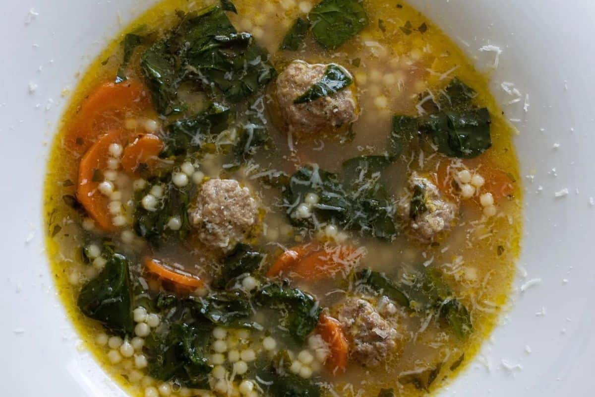 A comforting bowl of Italian wedding soup with meatballs, spinach, carrot slices, acini di pepe pasta, and broth—one of the best quick soups you can enjoy in under 30 minutes.