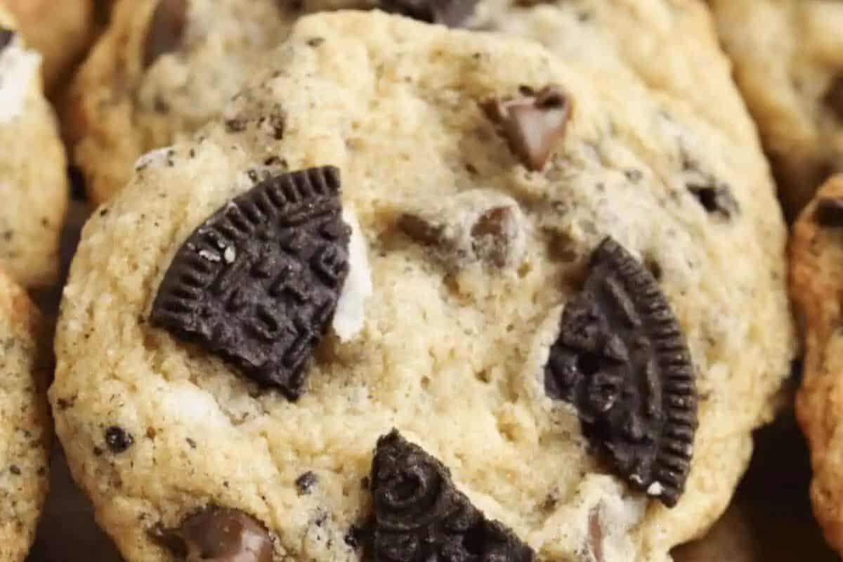A close-up of a cookie with pieces of chocolate sandwich cookies and chocolate chips embedded in it—one of the ultimate crowd-pleasing desserts for your next creative bake sale.