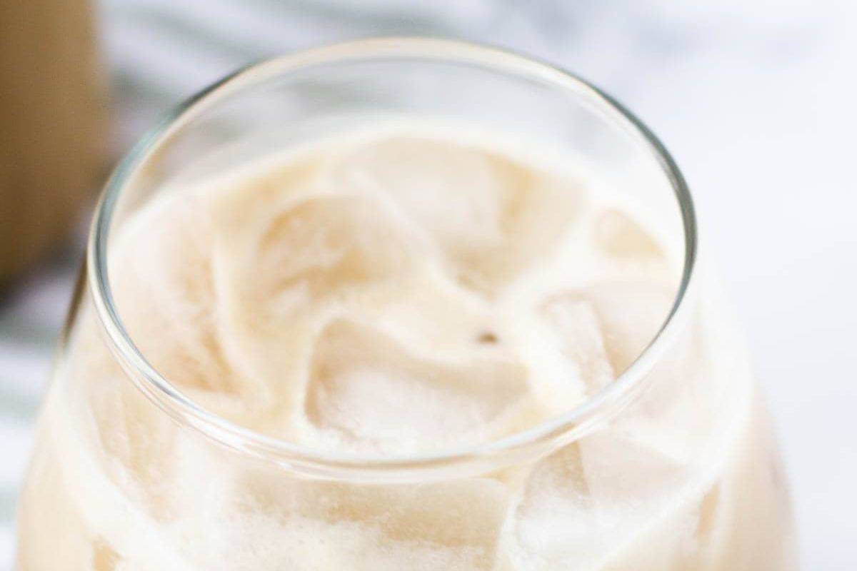 A glass filled with iced coffee, showcasing ice cubes and creamy swirls on top—perfect for savoring with an Irish spirit twist during St. Patrick’s Day celebrations.