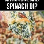 A close-up of a chip dipped into a creamy, hot artichoke and spinach dip, topped with browned cheese bits. In the background, more of this delicious Artichoke and Spinach Dip Recipe waits in a baking dish.
