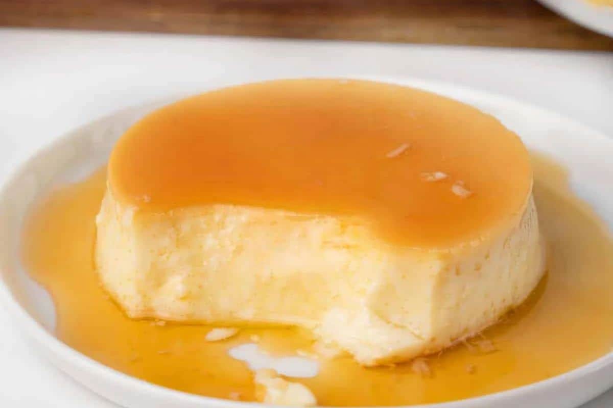 A round flan with caramel sauce on a white plate, partially eaten, makes for a delightful addition to any Cinco de Mayo fiesta dessert table.