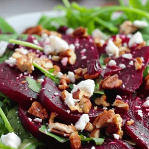A delightful spring salad features arugula, sliced beets, crumbled feta cheese, pecans, and cranberries—a perfect choice for the best seasonal recipes.