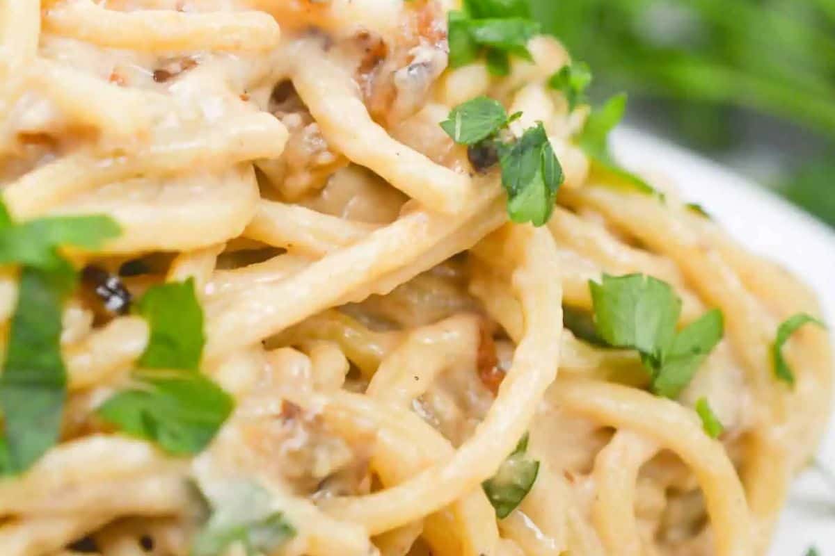 Close-up of a must-try creamy spaghetti with shallots, garnished with fresh parsley—a delightful addition to your spring pasta dishes collection.