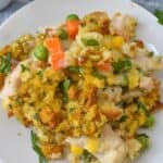 Savor a delightful dinner featuring a medley of mixed vegetables, tender chicken, and savory stuffing, all perfectly seasoned with carrots, peas, corn, and aromatic herbs.