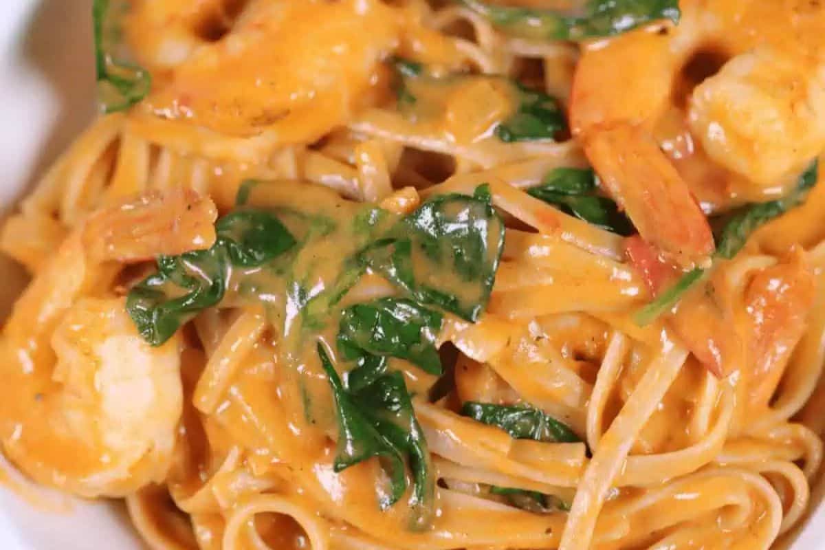 A delightful plate of creamy tuscan pasta, perfect for beginners, features succulent shrimp and fresh spinach enveloped in a rich, savory sauce.