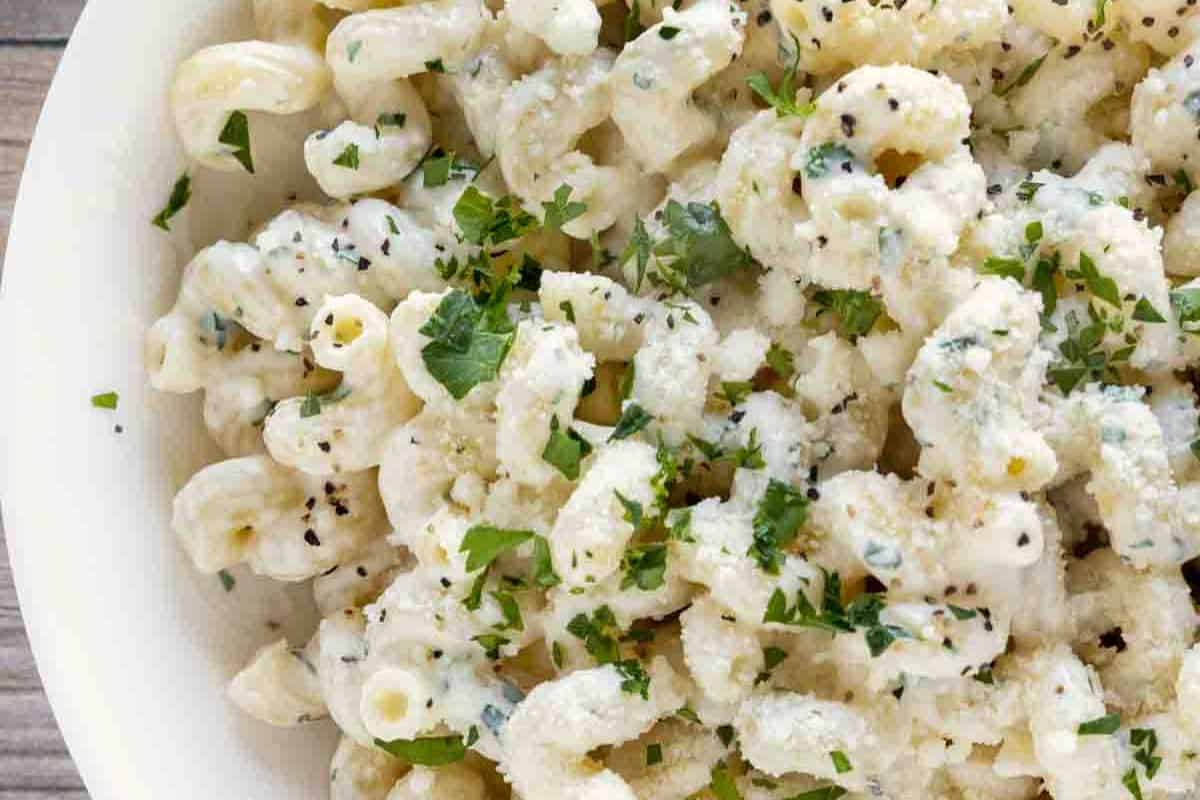 A perfect dish for beginners, this bowl of cavatappi pasta features a cream cheese sauce and is garnished with chopped parsley and black pepper.