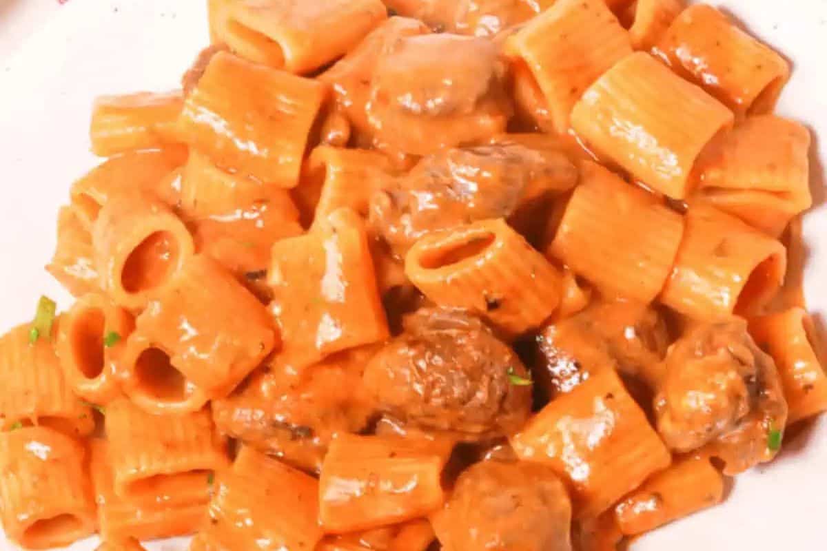 Close-up of a delightful spring rigatoni pasta with meatballs in a creamy tomato sauce.