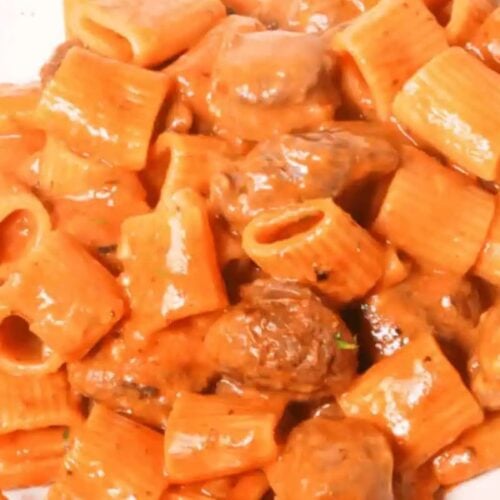Perfect for beginners, this dish features a delightful plate of short tube pasta smothered in a rich and creamy tomato sauce with savory meat.