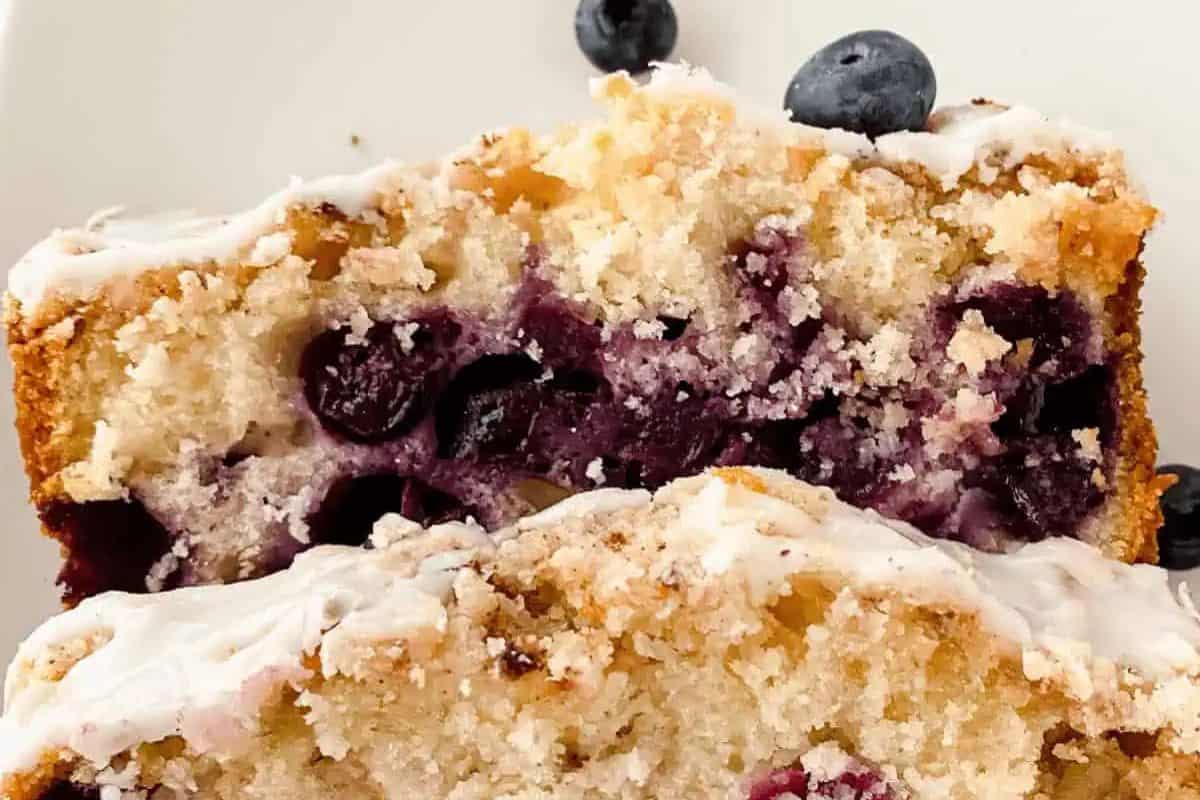 Slices of a lemon blueberry loaf with white icing on top, garnished with fresh blueberries, steal the spotlight at any Easter brunch.