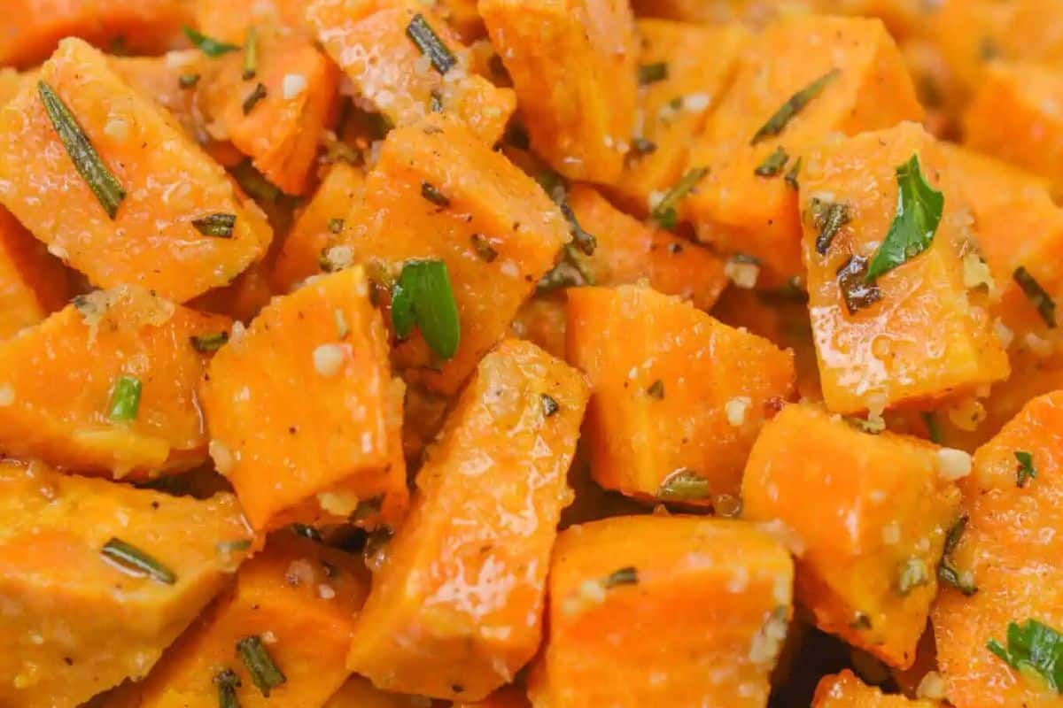 Close-up of roasted sweet potato cubes, an ideal addition to Easter side dishes, beautifully garnished with herbs and spices.