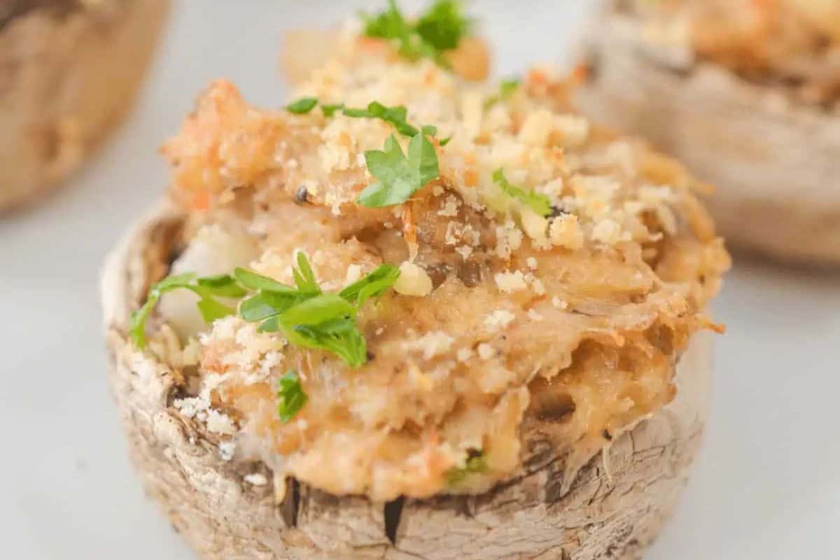 Close-up of a stuffed mushroom, a delightful side dish topped with breadcrumbs and garnished with parsley, perfect for Easter celebrations, set against a light background.