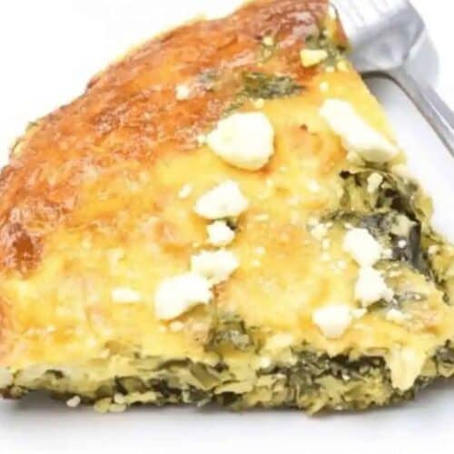 A perfect addition to your Easter brunch recipes, this slice of spinach and feta pie rests elegantly on a white plate, with a fork nearby.