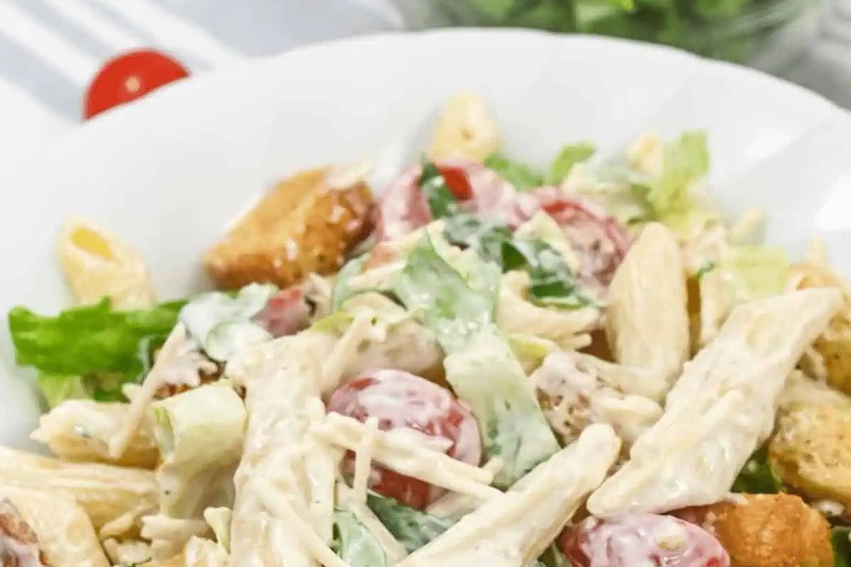 A creamy Caesar-dressed pasta salad with penne, crisp romaine lettuce, cherry tomatoes, shredded Parmesan, and crunchy croutons. The dressing clings to the pasta, making for a delicious fusion of classic Caesar salad and pasta.