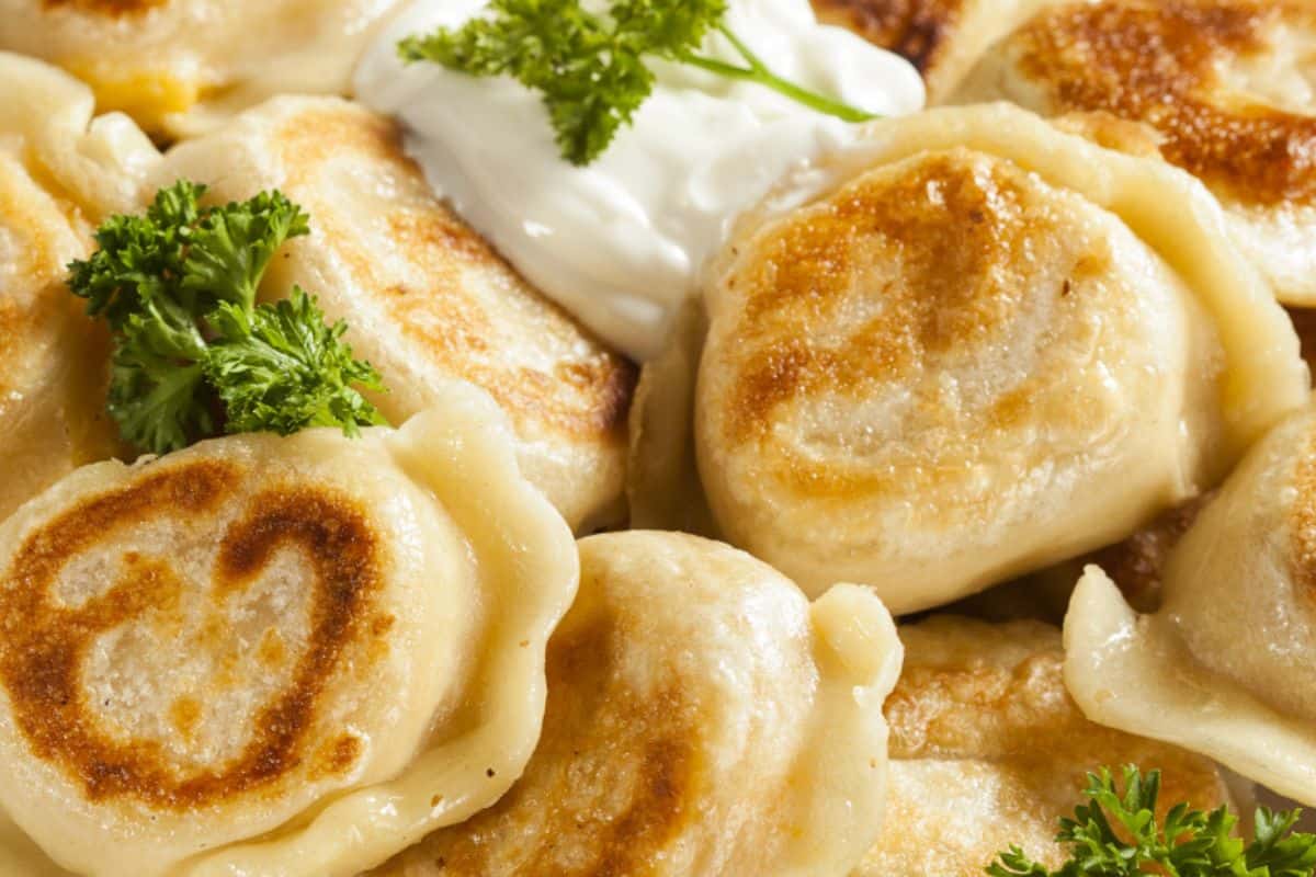 Pierogi cravings are fully satisfied with these delicious pan-fried dumplings, topped with a dollop of sour cream and garnished with fresh parsley.